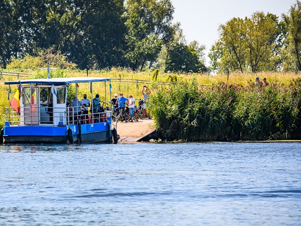 Veerpont aan de Maas met wachtende fietsers voor de oversteek