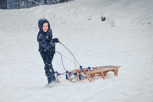 Little girl playing sledding in the snow