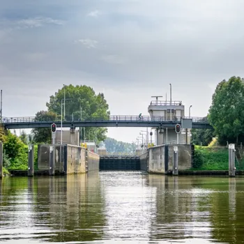 Sluis bij Osen met gesloten deuren, omringd door groen en rustige waterwegen.