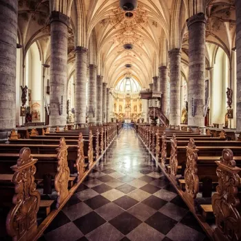 Interieur van de Sint-Martinuskerk in Weert met zuilen, gewelven en houten kerkbanken.